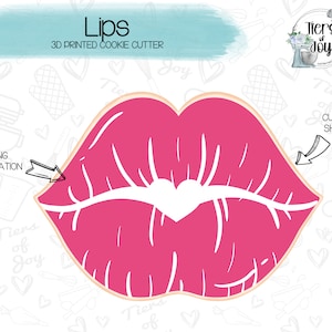 Peut inclure: Un emporte-pièce en forme de lèvres roses imprimé en 3D avec un cœur au centre. Le texte "Lips" et "3D Printed Cookie Cutter" est au-dessus de l'emporte-pièce. Le texte "ICING INSPIRATION" est sur le côté gauche de l'image avec une flèche pointant vers l'emporte-pièce. Le texte "CUTTER SHAPE" est sur le côté droit de l'image avec une flèche pointant vers l'emporte-pièce.