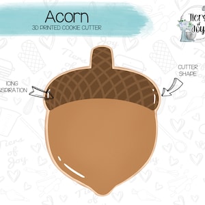 May include: A 3D printed cookie cutter in the shape of an acorn. The cutter is brown and has a detailed design on the top. The text "Acorn" and "3D Printed Cookie Cutter" is printed on the image.