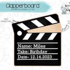 May include: A 3D printed cookie cutter shaped like a clapperboard. The clapperboard is black with white stripes and has the text "Name: Miles", "Take: Birthday", and "Date-12.14.2023" on it.