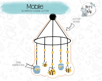 Peut inclure: Un emporte-pièce en 3D en forme de mobile pour bébé avec un cadre circulaire, cinq pots de miel suspendus et trois abeilles. L'emporte-pièce est conçu pour créer des biscuits pour une fête de naissance ou un thème de chambre d'enfant.
