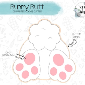 May include: A 3D printed cookie cutter shaped like a bunny's bottom with pink paw prints. The cutter is designed for use with icing and is part of a collection of cookie cutters.
