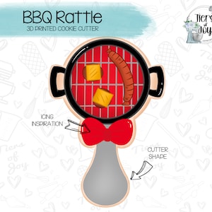 May include: A 3D printed cookie cutter shaped like a red and black grill with a sausage and cheese inside. The cutter has a grey handle with a red bow on top. The text "BBQ Rattle" and "3D Printed Cookie Cutter" is at the top of the image.