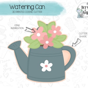 May include: A 3D printed cookie cutter in the shape of a watering can with flowers. The watering can is blue and the flowers are pink with white centers. The cookie cutter is on a white background with a pattern of hearts and kitchen tools.