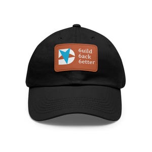Può includere: Cappellino da baseball nero con visiera curva. Il cappellino presenta una toppa rettangolare con la scritta "6uild back 6etter" e una grafica blu e bianca su sfondo marrone. Stile classico.