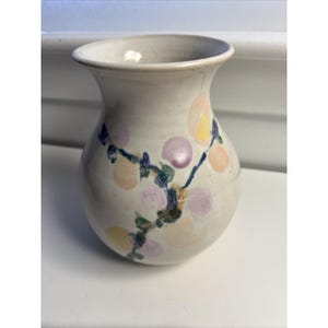 Può includere: Una tazza di ceramica bianca con manico nero e la scritta "But First, Coffee" in grassetto nero. La tazza è posta su uno sfondo sfocato, che suggerisce un'atmosfera accogliente.