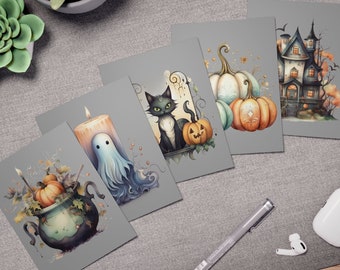 May include: Set of four Halloween-themed greeting cards featuring a black cat, a ghost, a cauldron, and a haunted house. Each card has a unique illustration and includes pumpkins, candles, and other spooky details.
