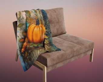 May include: A brown upholstered chair with a pumpkin-themed throw blanket draped over it. The blanket features a vibrant orange pumpkin with green leaves and a blue and green background. The chair has a simple, modern design.