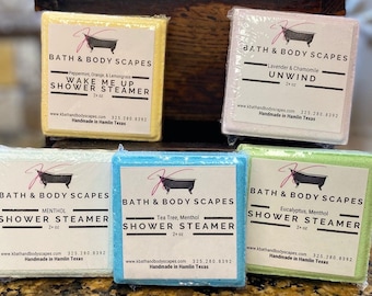 May include: Five square shower steamers with different scents and colors. The scents are Wake Me Up, Unwind, Menthol, Tea Tree, Menthol, and Eucalyptus, Menthol. Each steamer is 2 oz and is handmade in Hamlin, Texas.