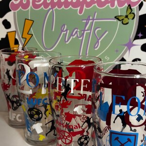 May include: Clear pint glasses with football-themed designs. Each glass features team logos, player silhouettes, and the text "20" and "PETE". The background includes a logo that says "Beauspoke Crafts".