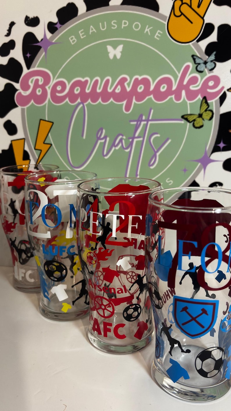 May include: Clear pint glasses with football-themed designs. Each glass features team logos, player silhouettes, and the text "20" and "PETE". The background includes a logo that says "Beauspoke Crafts".