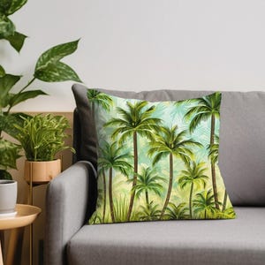 May include: A throw pillow with a tropical print featuring green palm trees against a light blue background.