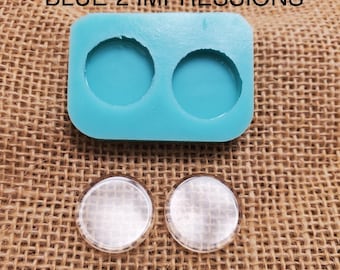 May include: A blue silicone mold with two round impressions. Two clear glass circles are shown next to the mold.