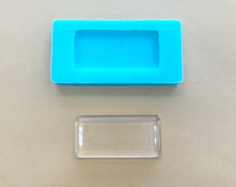 May include: A clear rectangular silicone mold with a light blue rectangular cavity. Next to the mold is a clear rectangular glass piece.