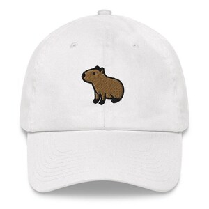 May include: White baseball cap with a brown embroidered capybara on the front.