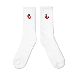 May include: A pair of white crew socks, each with a red chilli pepper embroidered near the top. The chilli peppers have green stems. The socks are made of a soft, comfortable material.