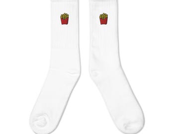 Puede incluir: Un par de calcetines blancos con un diseño de patatas fritas bordado en rojo y amarillo cerca de la parte superior. Los calcetines están hechos de un material suave y cómodo.