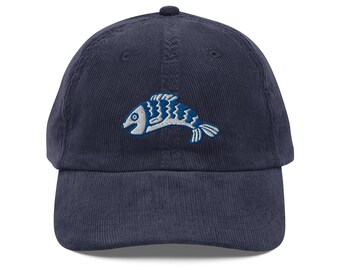 Op de afbeelding: Een donkerblauwe corduroy baseballpet met een geborduurd wit en blauw visontwerp.