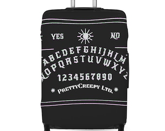 Può includere: Valigia nera con ruote con un design a tavola Ouija. Il design include l'alfabeto, i numeri e le parole "YES" e "NO". Il testo "PRETTY CREEPY LTD." è anch'esso visibile.