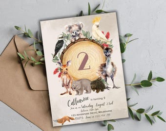 Op de afbeelding: Een aquarel-illustratie van Australische dieren, waaronder een koala, een kookaburra, een echidna en een wombat, die een houten schijf met het nummer 2 omringen. De tekst "Catharine wordt 2" staat onderaan de uitnodiging, samen met de datum, tijd en locatie van het feest.