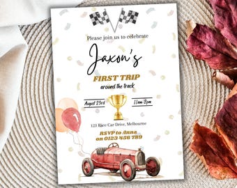 May include: A white invitation with gold and red accents for a child's first birthday party. The invitation features a red vintage race car, a gold trophy, and the text "Jaxon's First Trip around the track".
