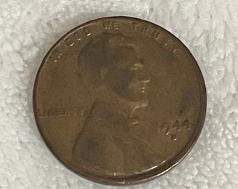 Op de afbeelding: Een koperkleurige Amerikaanse penny uit 1944 met het profiel van Abraham Lincoln op de voorzijde en de woorden "IN GOD WE TRUST" en "LIBERTY" rond de rand.