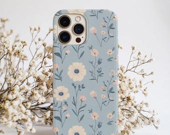 Könnte beinhalten: Hellblaue Handyhülle mit floralem Muster. Das Muster wiederholt cremefarbene Blumen mit blauen Zentren und kleinen rosa Blüten sowie grüne Blätter und Stiele. Die Hülle hat eine glänzende Oberfläche.