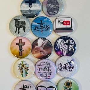 Könnte beinhalten: Eine Sammlung runder, farbenfroher Knöpfe mit religiösen Themen. Designs umfassen Kreuze, Texte wie "Jesus rettete mein Leben" und inspirierende Zitate. Die Knöpfe weisen verschiedene Farben und Grafiken auf.