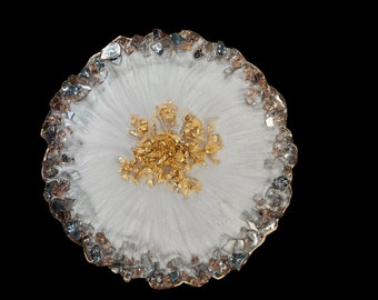 May include: A white resin coaster with a gold glitter design and a silver glitter border.