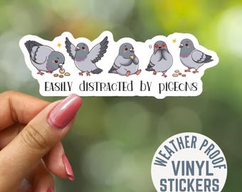 May include: A white vinyl sticker featuring five cartoon pigeons in various poses, including eating, flapping wings, and blushing with heart eyes. The text below the pigeons reads "EASILY DISTRACTED BY PIGEONS" in a dark, stylized black font.