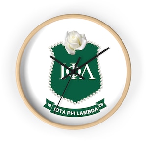 May include: A white and green clock with a white rose and pearl accents. The clock face features the letters "IΦΛ" and the text "IOTA PHI LAMBDA" with the numbers "19" and "29".