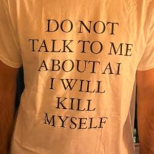 May include: White t-shirt with the text "DO NOT TALK TO ME ABOUT AI I WILL KILL MYSELF" in black, centered on the front. The shirt has short sleeves and a crew neck.