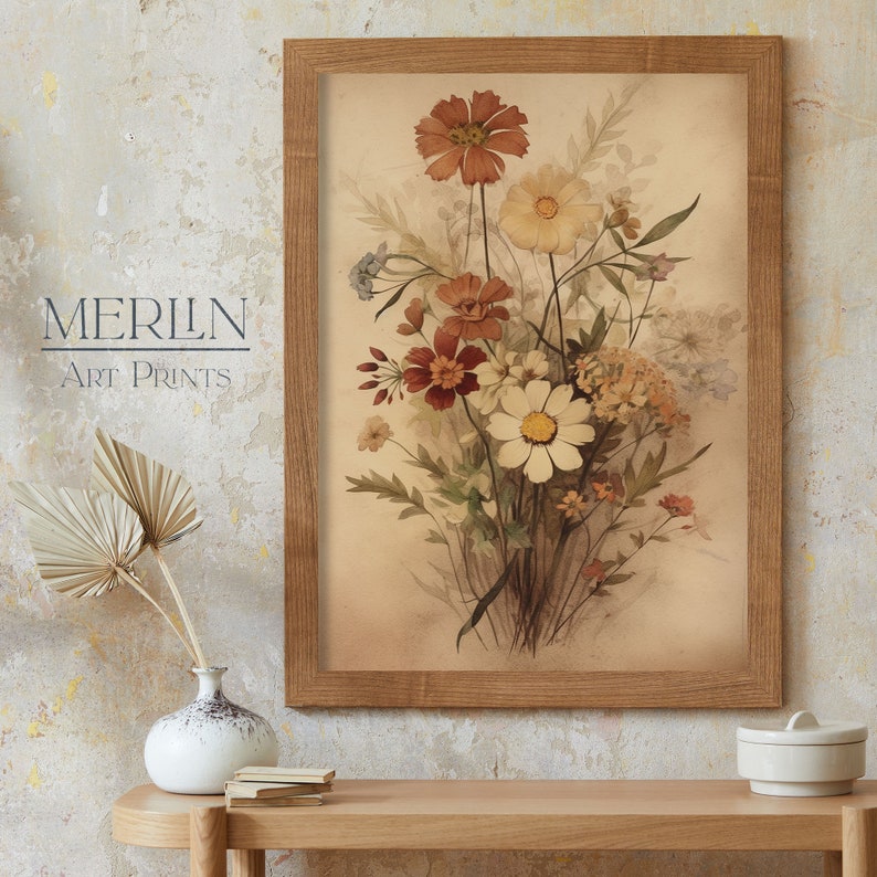 May include: A framed vintage botanical print featuring a bouquet of delicate wildflowers in shades of brown, white, and red. The flowers are arranged in a vase and are set against a light brown background.