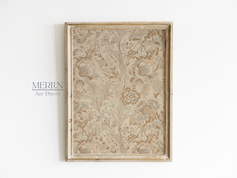 May include: A framed print with a beige background and a floral pattern in shades of brown and white. The frame is a light wood color with a distressed finish.