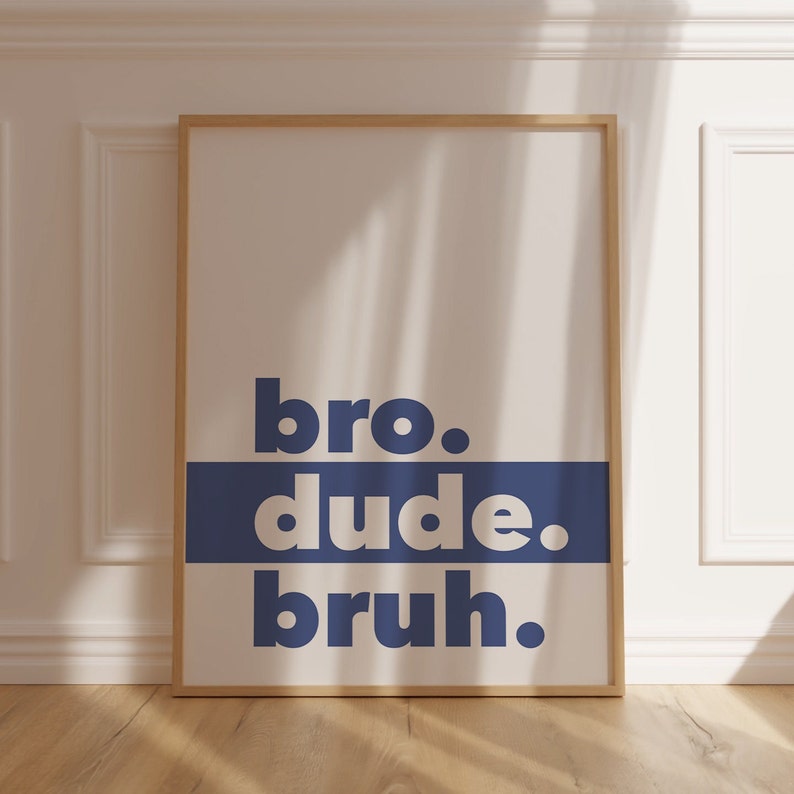 May include: A framed poster with the words "bro. dude. bruh." in a bold, white font on a blue background. The poster is hanging on a white wall.