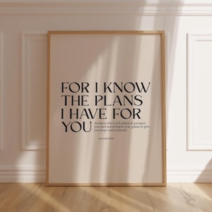 May include: A framed print featuring the words "FOR I KNOW THE PLANS I HAVE FOR YOU" in black. The print has a beige background and a light brown frame. The text includes a quote from Jeremiah 29:11.