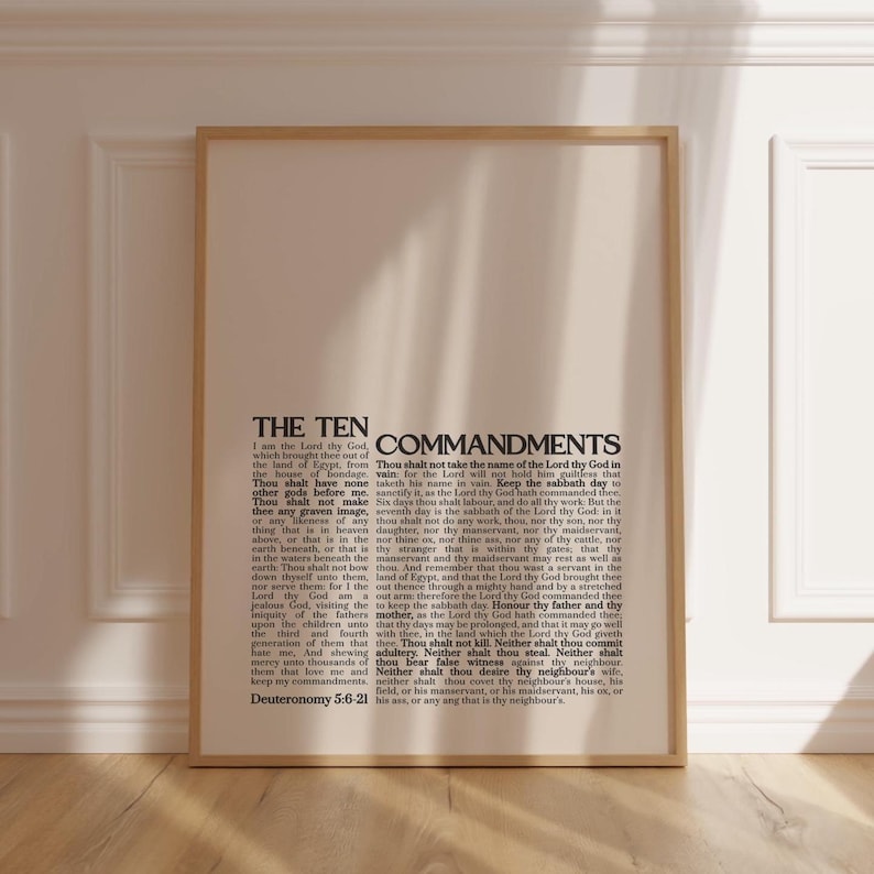 May include: A framed print featuring the text "THE TEN COMMANDMENTS" in a classic serif font. The text is printed in black on a cream-colored background, with the full text of the Ten Commandments. The frame is a light wood color.