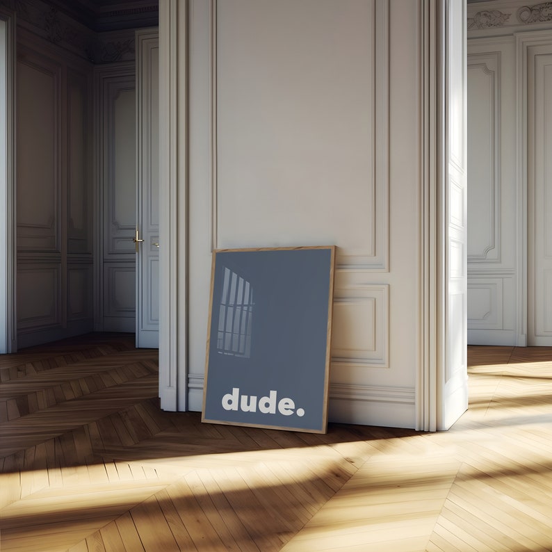 May include: A framed poster with a blue background and a white window silhouette. The text "dude." is printed in white at the bottom of the poster.