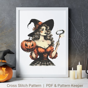 May include: Cross stitch pattern of a witch with a black hat and orange dress holding a pumpkin and a wand with a spark at the end. The background is white.