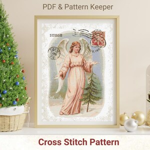 May include: A framed cross-stitch pattern depicting an angel in a flowing gown, with wings and a small fir tree. The artwork has a vintage aesthetic, with postage stamp details and the word "SUISSE". The text "PDF & Pattern Keeper" and "Cross Stitch Pattern" are also visible.