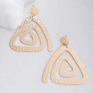May include: A pair of gold-toned earrings with a hammered texture. Each earring features a double triangle design with a smaller triangle inside a larger triangle.