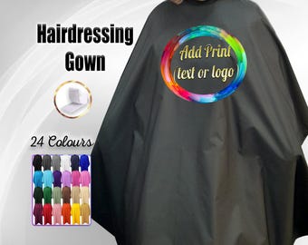 Op de afbeelding: Zwarte kappersjas met een kleurrijk cirkelontwerp met de tekst "Add Print (text or logo)". De jas wordt getoond op een model. Er zijn 24 kleuren beschikbaar.