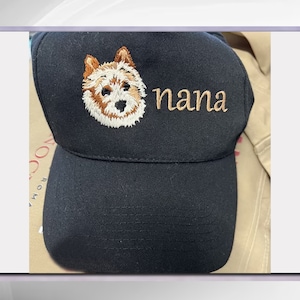 May include: Black baseball cap with an embroidered image of a dog and the word "nana" in brown thread.