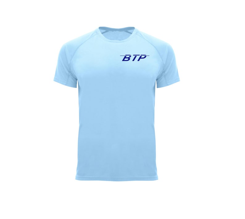 May include: A light blue short-sleeved athletic shirt with the text "BTP" in dark blue on the chest. The shirt has a crew neck and raglan sleeves. The fabric appears to be a lightweight, breathable material.
