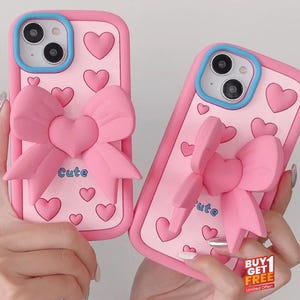 3D-Karikatur-Rosa-Liebes-Bogen-Halter-Telefon-Kasten für iPhone 16 15 14 Plus 13 12 Pro Max kaufen 1 erhalten 1 frei