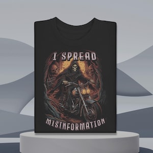 May include: Black t-shirt with a graphic of the Grim Reaper riding a motorcycle. The design includes the text "I SPREAD MISINFORMATION" in white. The artwork features skulls and a dark, ominous color palette.