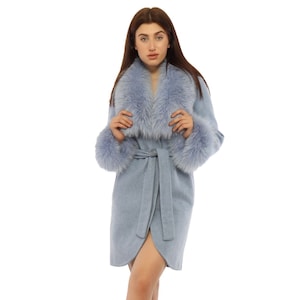 May include: A light blue coat with a faux fur collar and cuffs. The coat has a wrap design with a matching belt. The model is wearing black combat boots.