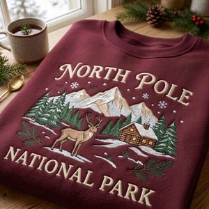 Sweatshirt met geborduurde afbeelding van het Nationaal Park Noordpool, trui met ronde hals en rendiermotief in een berghut, vintage kersttrui met outdoor-thema.