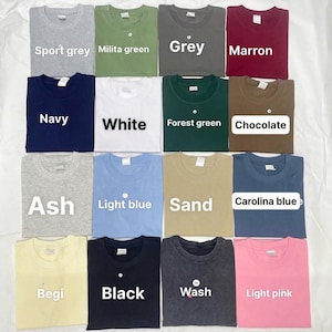 Pode incluir: Uma cole&ccedil;&atilde;o de dezasseis t-shirts de manga curta com gola redonda dispostas numa grelha, apresentando v&aacute;rias cores s&oacute;lidas, incluindo sport grey, military green, grey, maroon, navy, white, forest green, chocolate, ash, light blue, sand, Carolina blue, beige, black, wash e light pink.