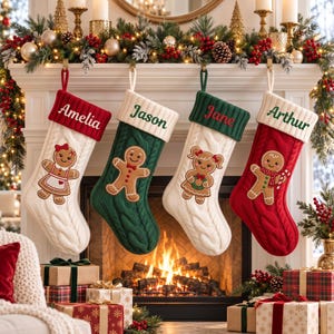 Peut inclure: Quatre chaussettes de Noël en tricot torsadé suspendues. La première est blanche avec un revers rouge marqué Amelia et une fille en pain d'épice. La deuxième est verte avec un revers blanc marqué Jason et un garçon en pain d'épice. La troisième est blanche avec un revers vert marqué Jane et une fille en pain d'épice. La quatrième est rouge avec un revers blanc marqué Arthur et un garçon en pain d'épice.