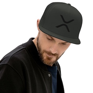 May include: A black trucker hat with a black X-shaped logo on the front. The hat is worn by a person with a beard.